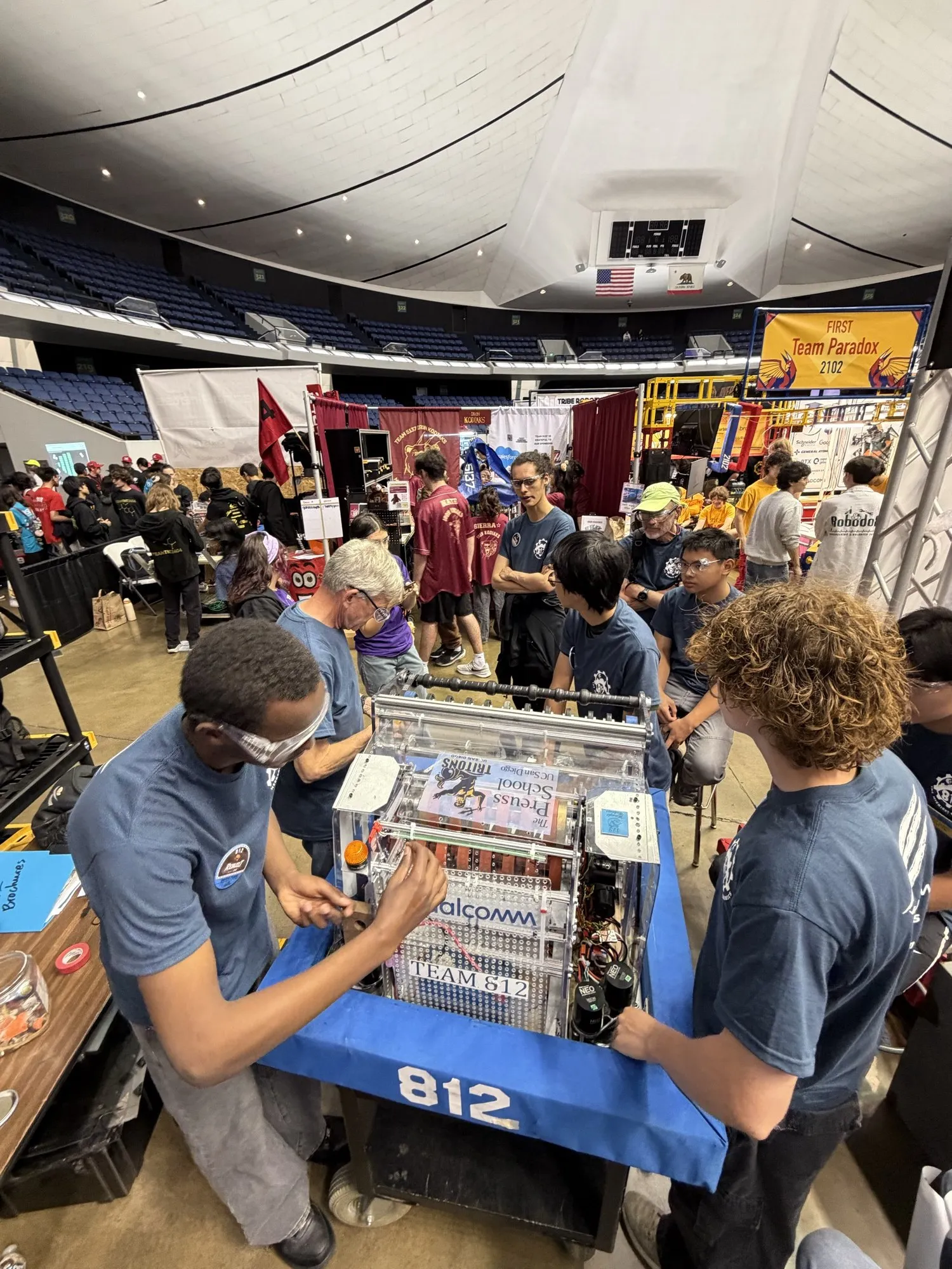 Students and a mentor working on the robot, with TEAM 812 on the bumper.